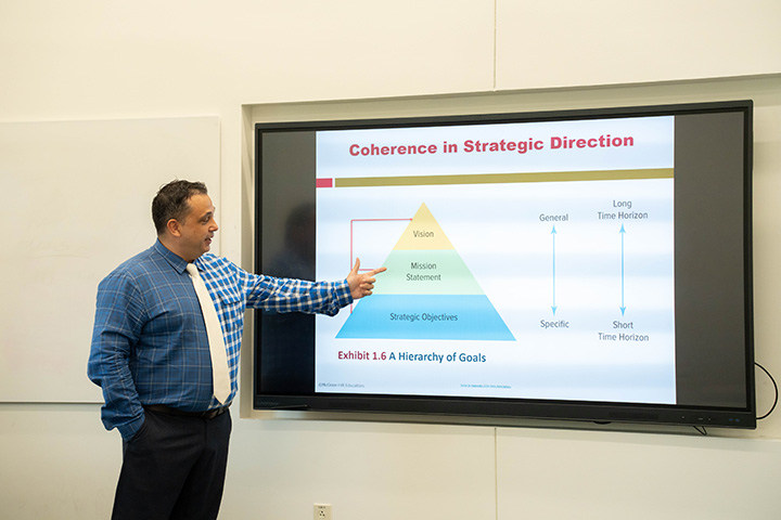 Dr. Verbeck Pointing at Chart in Classroom