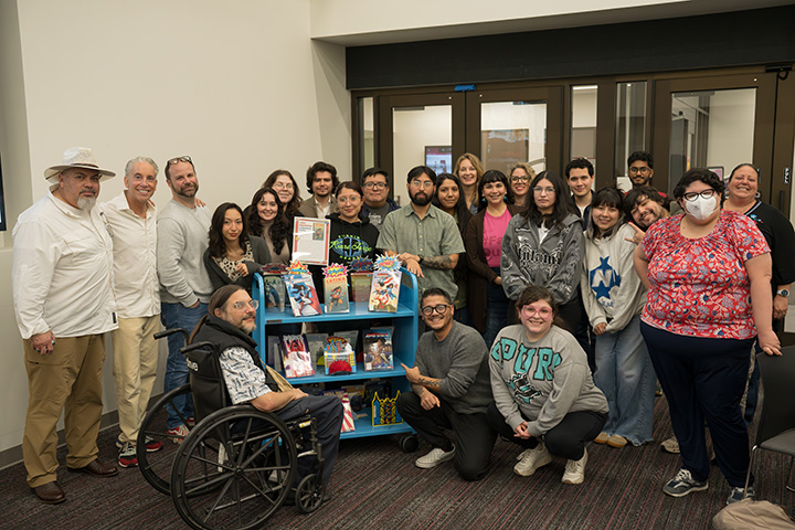 Students and Staff with Bookshelf of Latinx Graphic Novels